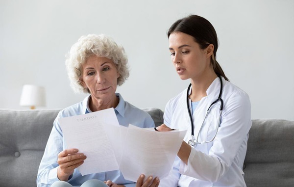 Older female patient looking at paperwork with a doctor
