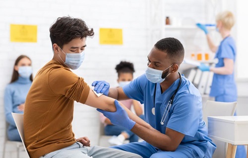 Young patient having his arm swabbed by a doctor
