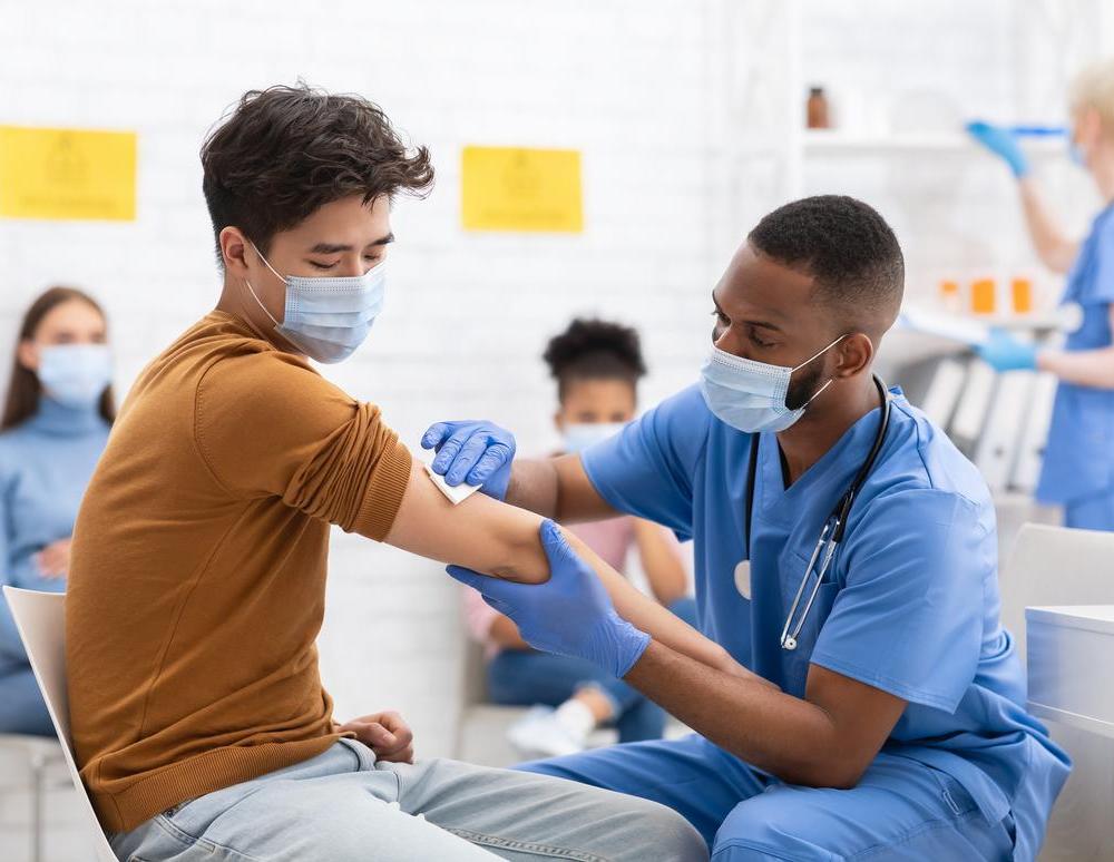 Young patient having his arm swabbed by a doctor