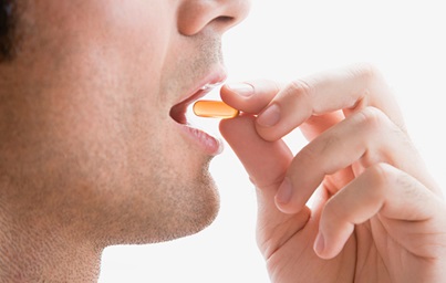 Man taking an orange pill
