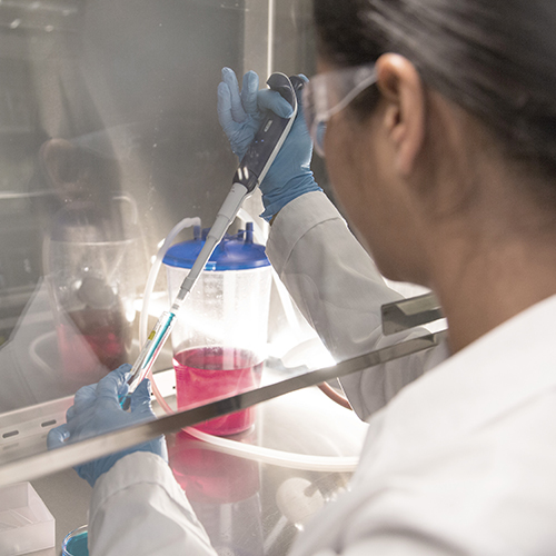 Female technician working with equipment in a biopharmaceutical laboratory