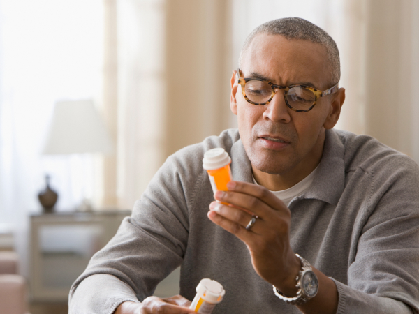 Person with concerned expression reading medication bottle label